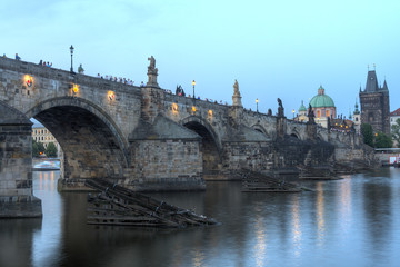 Fototapeta na wymiar View on eastern side of Charles Bridge with tower and dome of Clementinum in Prague, Czech Republic 