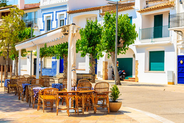 Fototapeta na wymiar Restaurant tables on street of small fishing village of Llafranc, Costa Brava, Spain