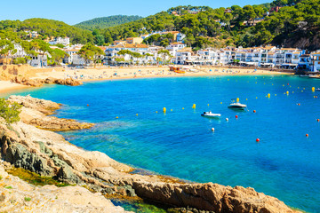 Stunning sandy beach and azure blue water of sea bay in Tamariu seaside town, Costa Brava, Spain