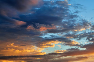 The sky at sunset. Cumulus clouds lit by the rays of the setting sun.