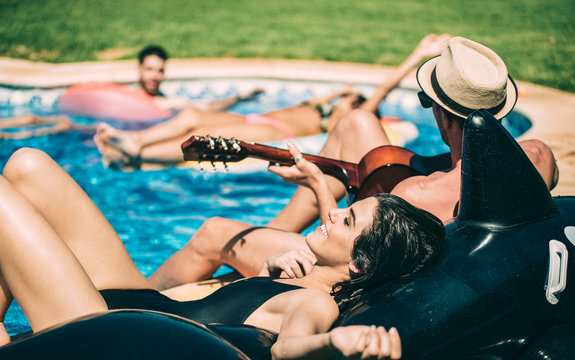 Men and women relaxing in poolside - Powered by Adobe