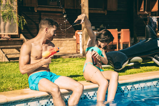 Couple having fun sitting at swimming pool
