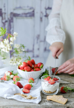 Faceless chef using fresh juicy tasty strawberries while preparing creamy sweet dessert
