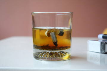 Close up of cigarettes in a glass of water.