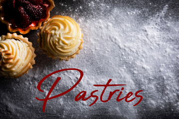 Pastries, creamy muffins on a flour background.