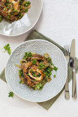 Ossobuco alla milanese - Lombard cuisine of cross-cut veal shanks, made with white wine, broth and green peas.