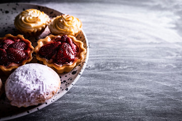Dessert, pudding muffins, cream cakes and mini tarts with raspberries