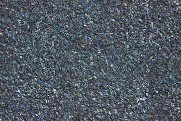 Texured roofing felt surface with many small grey stones