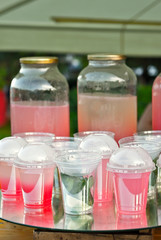 Multicolored fruit drinks close-up. Non-alcoholic drinks in plastic cups at the festival. Cocktails with juice and greens.