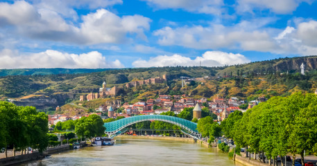 Fototapeta na wymiar Hills of old Tbilisi and modern glass Peace bridge, Georgia