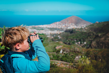 Fototapeta na wymiar young boy looking through binocular on travel in nature