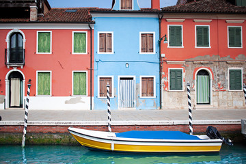 Colorful buildings near a boat in Burano island in Venice. Italian street