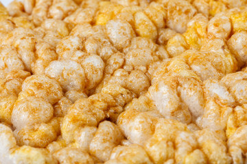 Caramelized corn cakes. Puffed whole grain crispbread isolated on white background. Close-up.