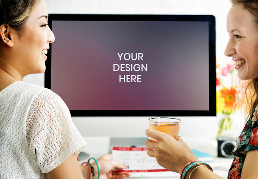 Two People Laughing near Computer Mockup