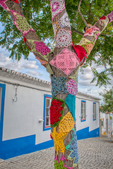Trees decorated with colorful crochet patchwork on a holiday in the town of Mertola, a very beautiful city in the Portuguese Alentejo area