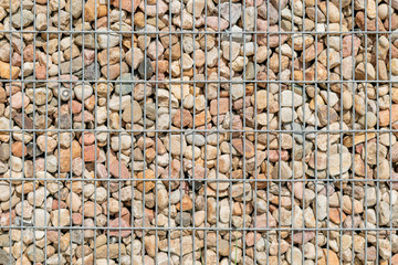 Textured background, pebbles behind steel bars