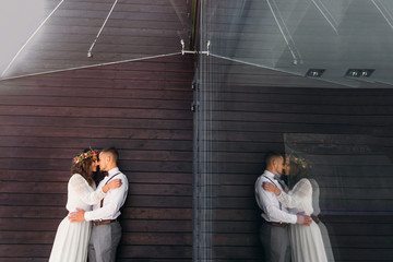 hug a couple in love near the wooden wall. reflection in the gla