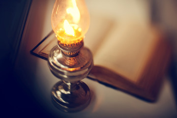 Vintage kerosene lamp and old open book - 273760716