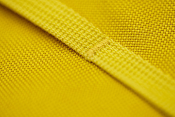 Detail of a yellow sports backpack. Stitched strap