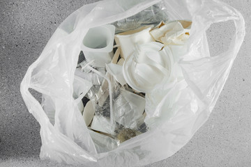 White single use plastic in plastic bag.  Closeup. Concept of Recycling plastic and ecology. Flat lay, top view.