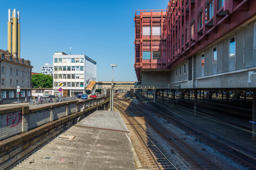 Fototapeta premium Unique hidden view above railway from the back of Bahnhof Basel SBB, Basel Main Train Station, and post office building against blue sky in summer season in Basel, Switzerland.