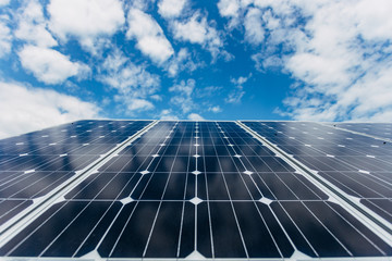 Solar panels on blue cloudy sky background