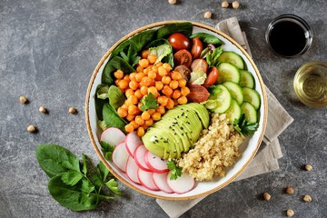 Healthy vegetarian salad with chickpeas, quinoa, cherry tomatoes, cucumber, radish, spinach,...