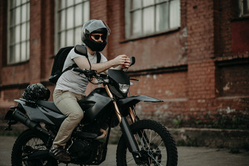 Fototapeta na wymiar man enduro motorcycle driver in the city. biker in a helmet.