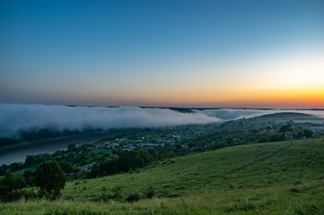 Foggy morning in the village on the river bank