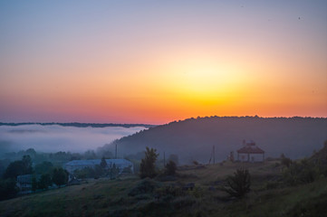Foggy morning in the village on the river bank