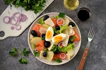 Salad with baby potatoes salted salmon, black olives, red onions, parmesan and lettuce. Organic healthy food. Top view. 