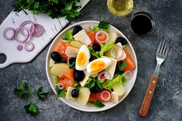 Salad with baby potatoes salted salmon, black olives, red onions, parmesan and lettuce. Organic healthy food. Top view. 