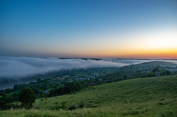 Fototapeta premium Foggy morning in the village on the river bank