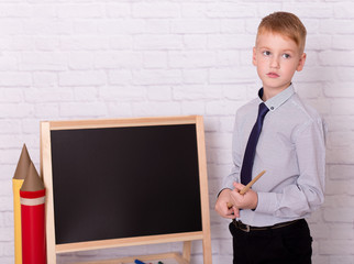  Caucasian schoolboy  is holding a pointer. Portrait of a little boy holding pointer on her hands. Little caucasian boy on abstract background.