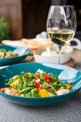 Healthy fruit platter, strawberries raspberries oranges plums apples kiwis grapes blueberries on the dark grey wooden table, top view, close up, selective focus