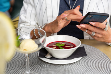 A girl makes selfie food while having lunch in a restaurant. Close-up copy space.