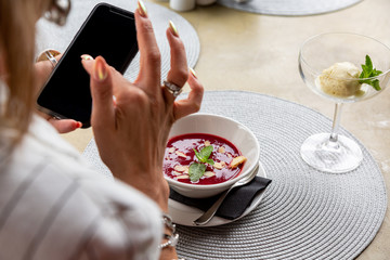 A girl makes selfie food while having lunch in a restaurant. Close-up copy space.