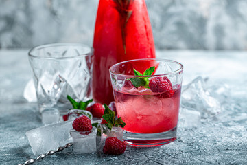 Raspberry cocktail, fizz, lemonade, ice tea with fresh mint on blue wooden background. Close up.
