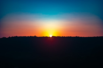 Sunrise over the forest on a summer day