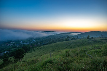 Foggy morning in the village on the river bank