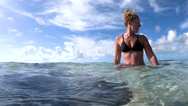 woman at exuma island with stingrays in the water