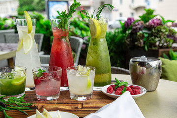 Summer soft drinks, a set of lemonades. Lemonades in jugs on the table, the ingredients of which they are made are arranged around.