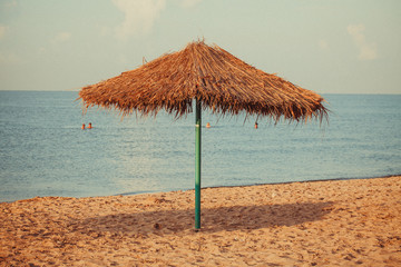 Umbrella of reeds on the beach. Summer mood. Best beach vibes
