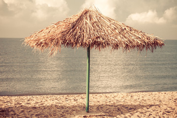 Umbrella of reeds on the beach. Summer mood. Best beach vibes