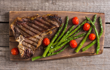 Grilled T-bone steak with asparagus and cherry tomatoes