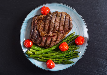 Grilled beef steak ribeye with cherry tomatoes and asparagus