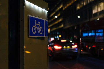 Bike sign with blurred cars in the background.