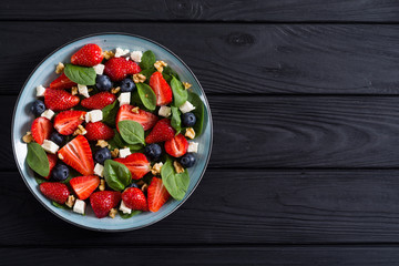 Summer Strawberry salad with spinach , cheese , nuts and blueberry