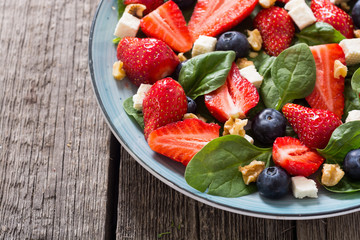 Summer Strawberry salad with spinach , cheese , nuts and blueberry