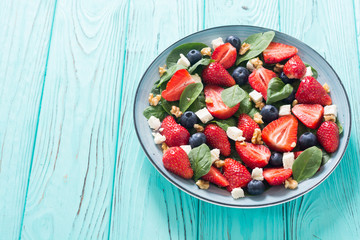 Summer Strawberry salad with spinach , cheese , nuts and blueberry
